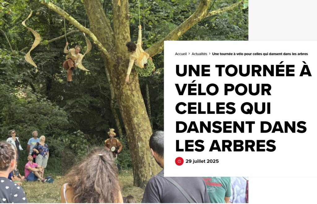 Des artistes costumés dansent et se suspendent aux branches d'un arbre dans une zone boisée, présentant un article féerique dansant dans les arbres sous le regard du public.